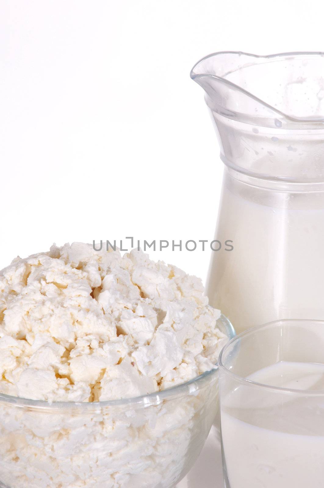 Jug with milk, a glass and a dish with cottage cheese