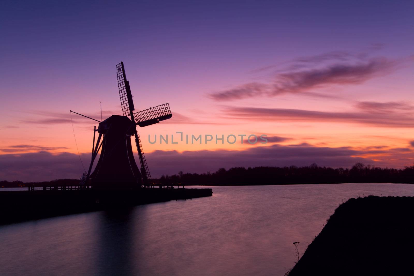 windmill silhouette over colorful sky during sunset in Groningen