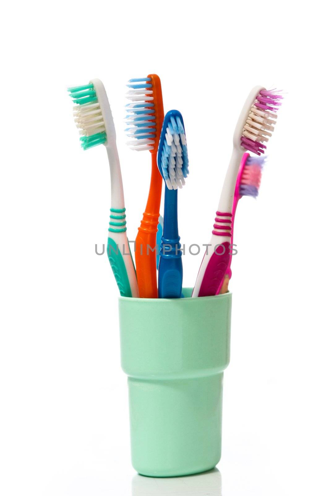 Tooth brushes in glass on a white background