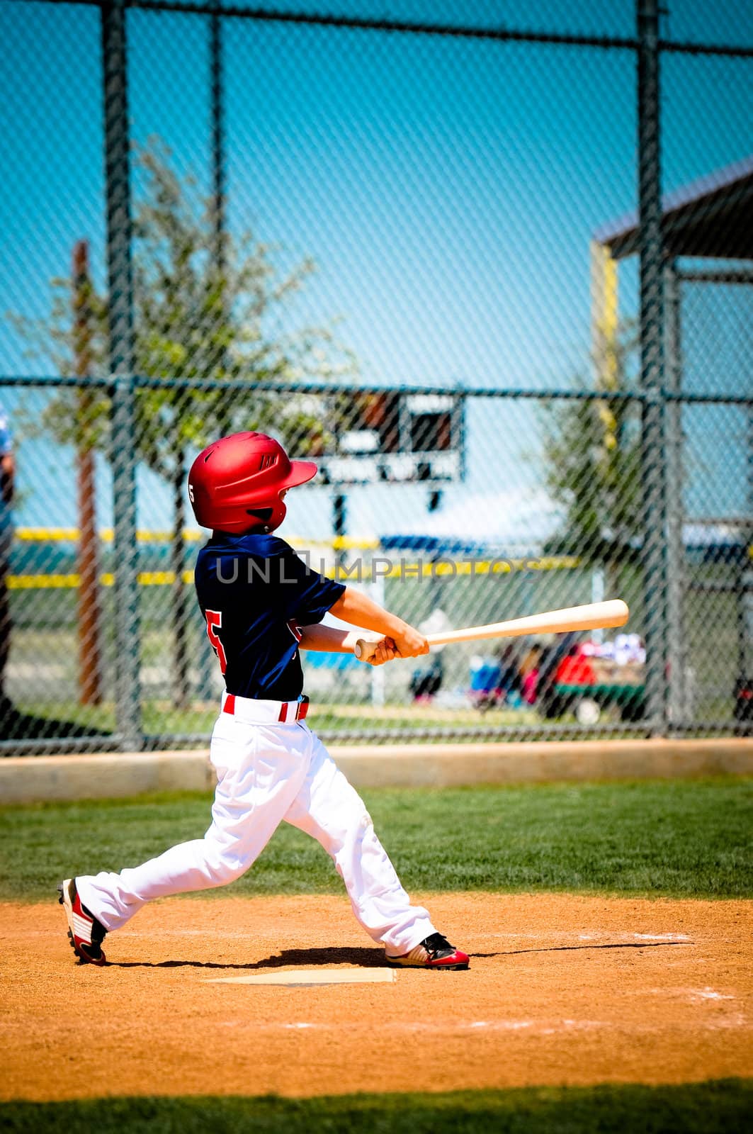 Little league baseball player swinging the bat