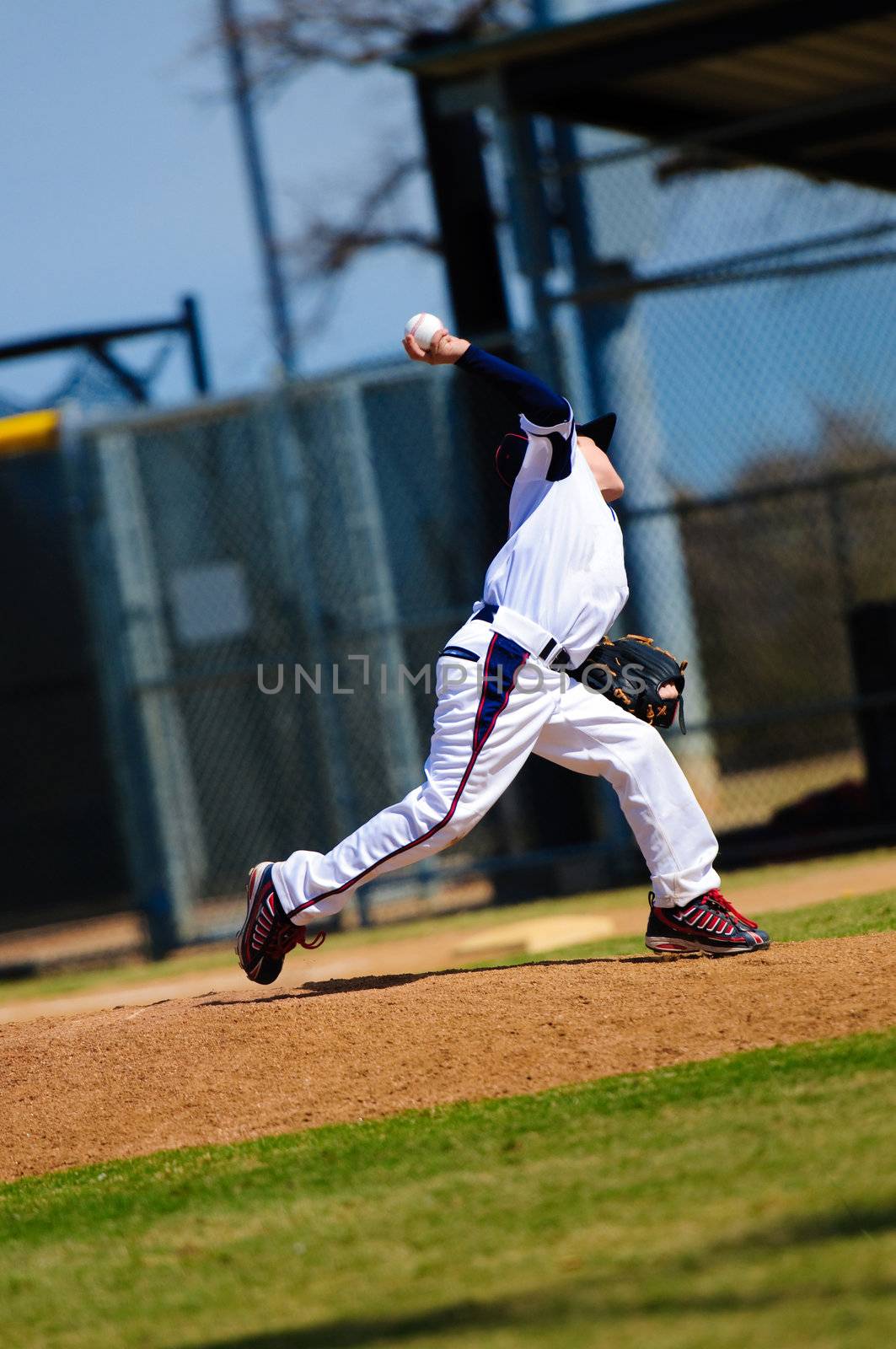 Little league baseball pitcher in the middle of a pitch.