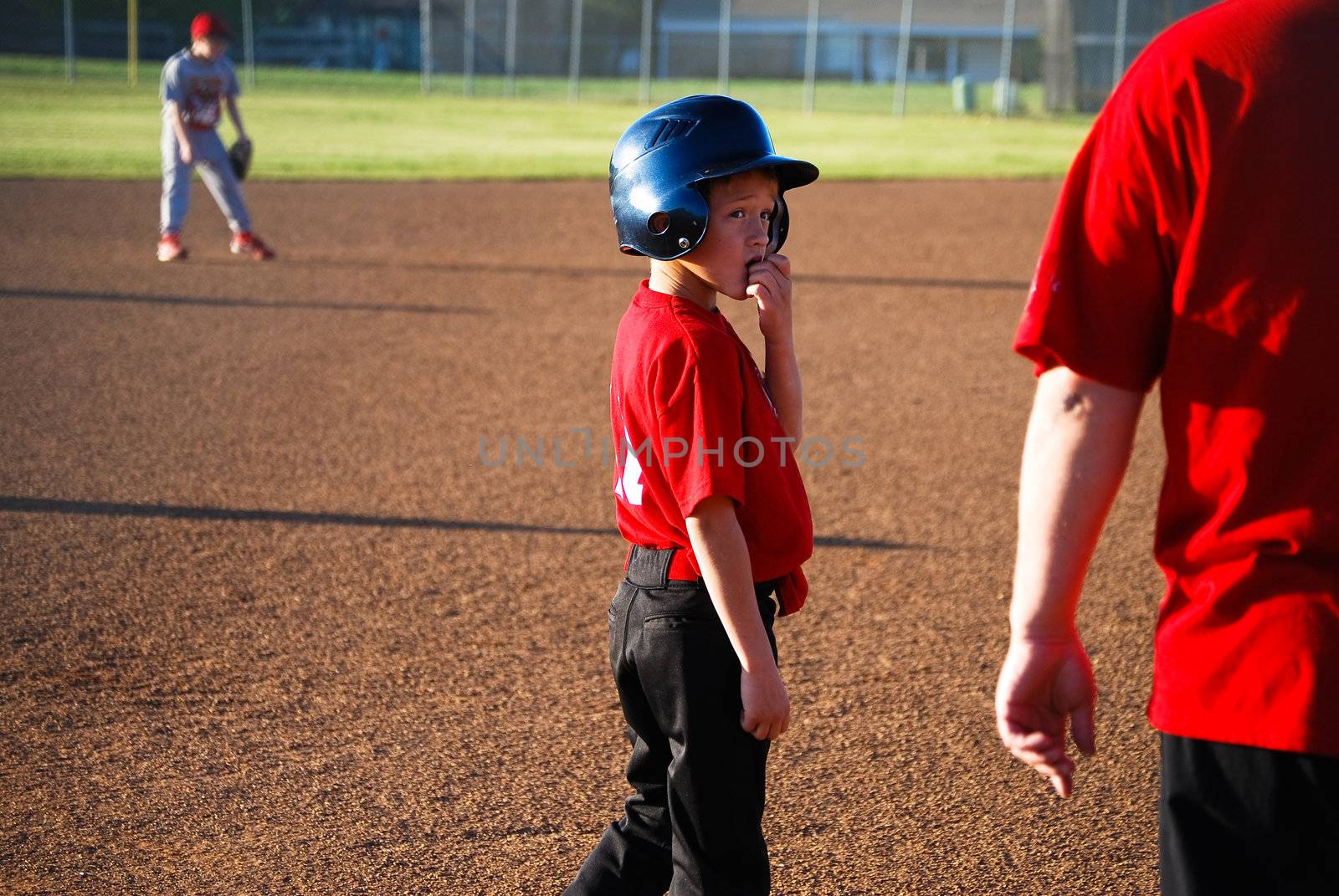 Youth baseball player looking back at coach.