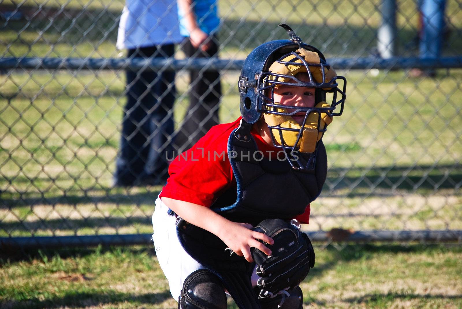 Lilttle league baseball catcher looking at camera.