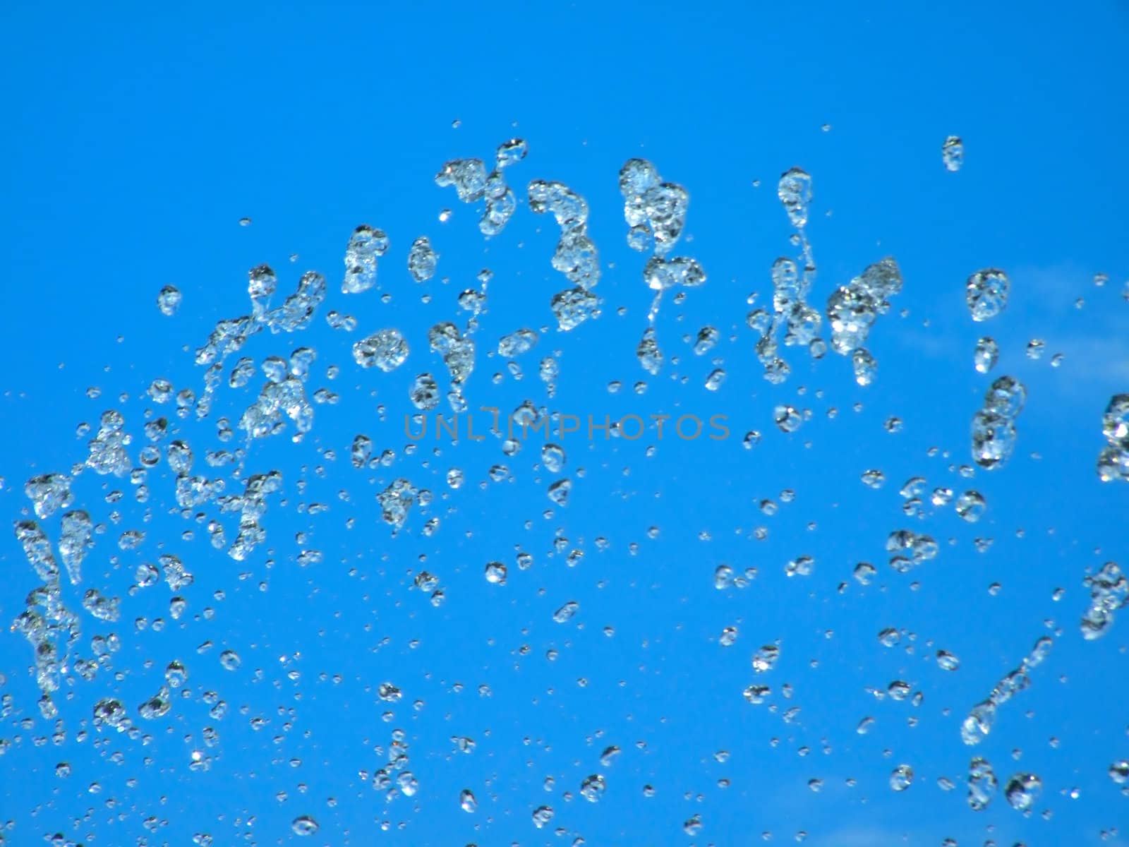 Splashes of a fountain against the blue sky