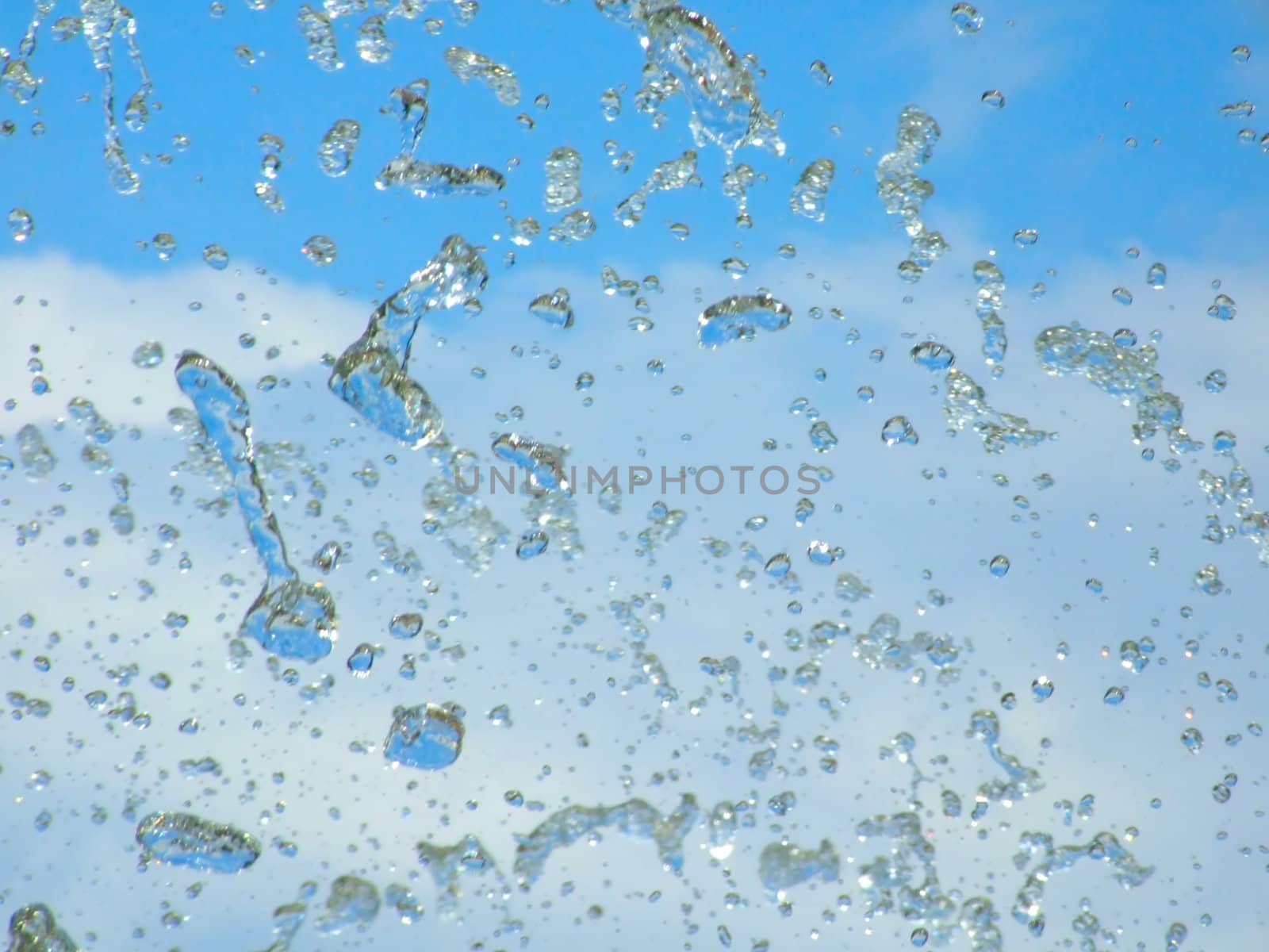 Splashes of a fountain against the blue sky