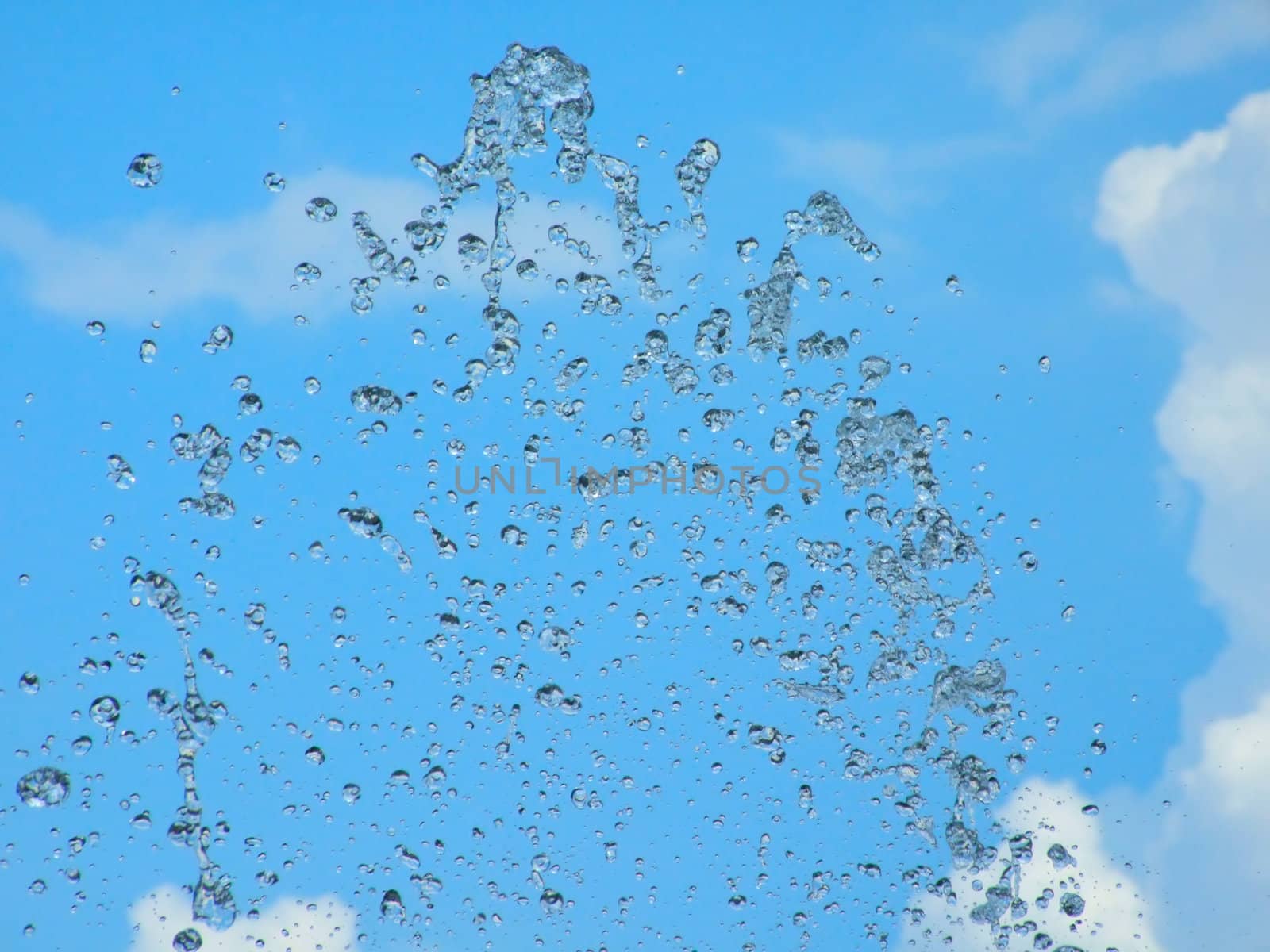 Splashes of a fountain against the blue sky