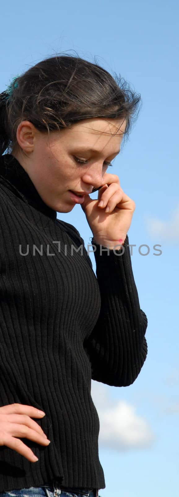 young teenager and her phone in a blue sky