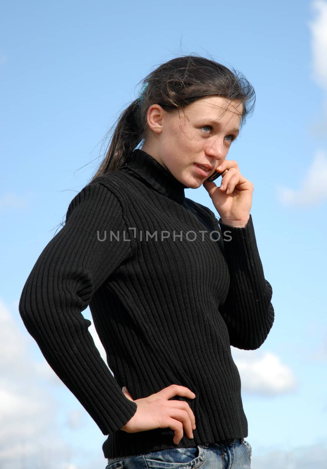 young teenager and her phone in a blue sky