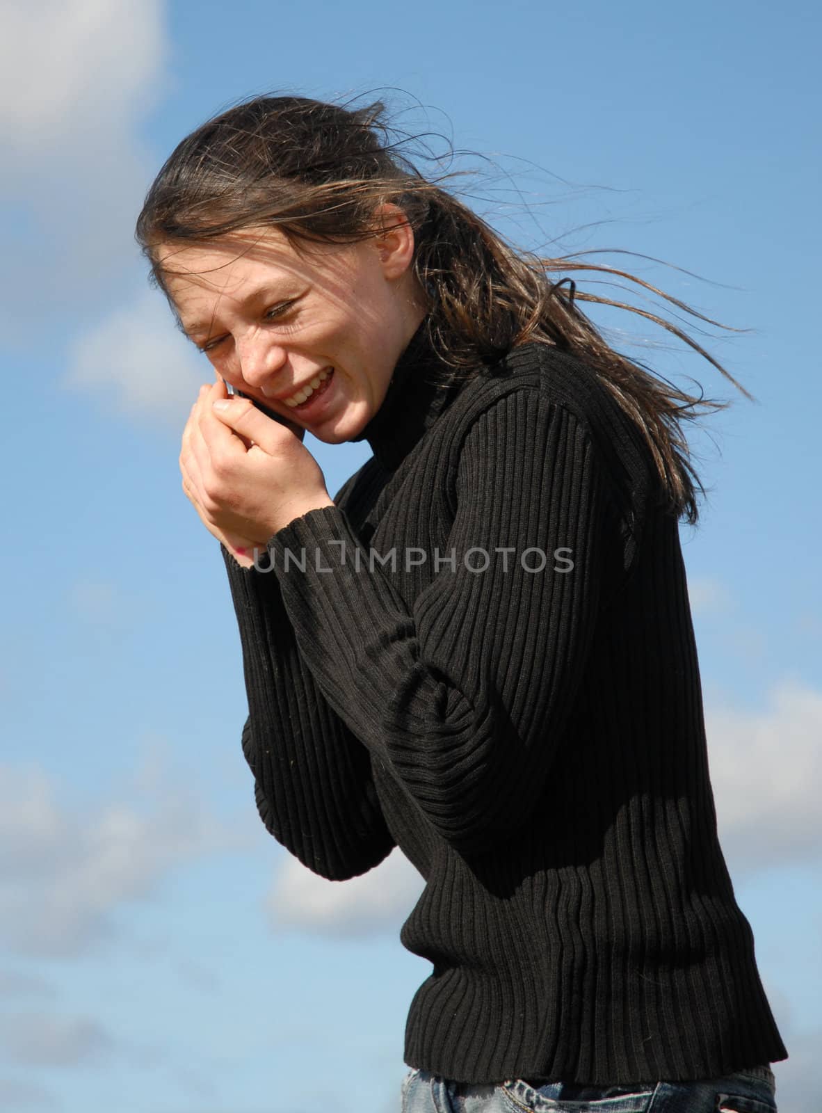 young teenager and her phone in a blue sky