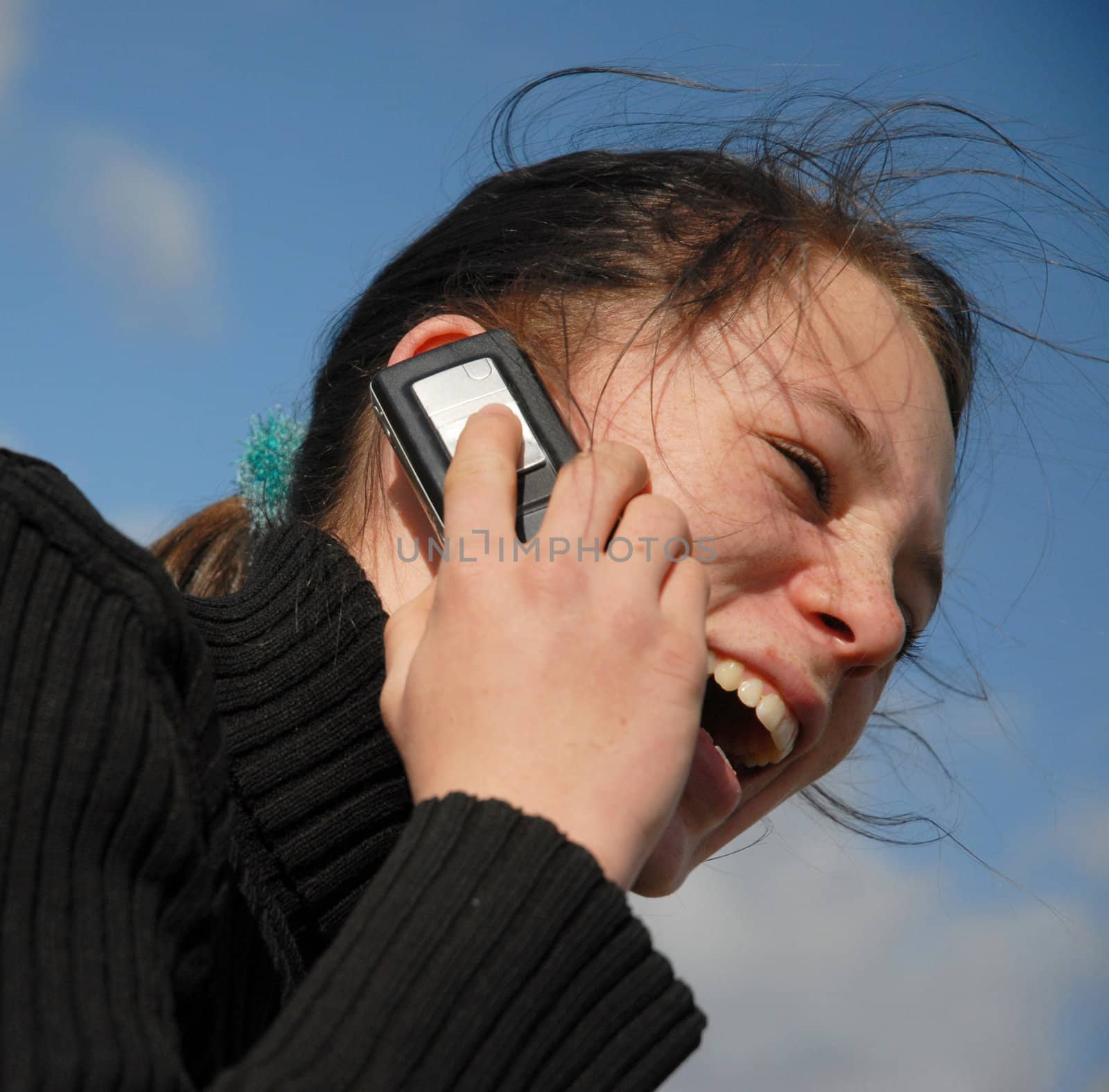 young teenager and her phone in a blue sky