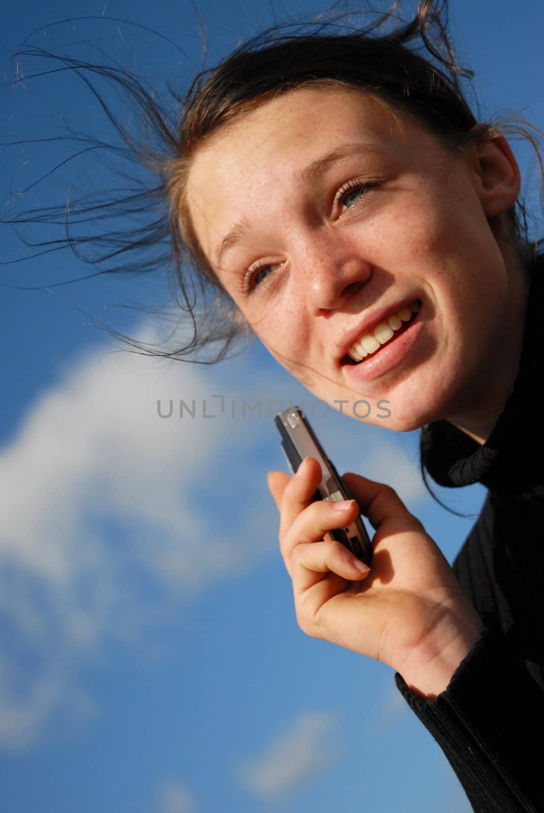 young teenager and her phone in a blue sky