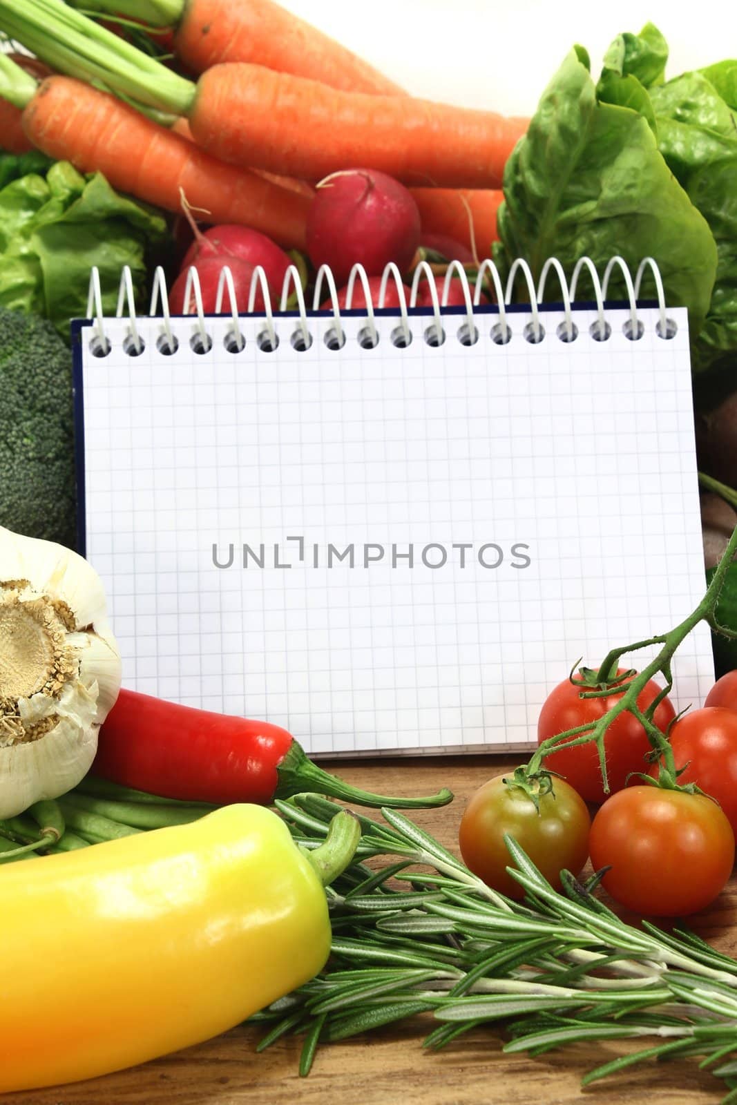 a checkered note pad and various vegetables