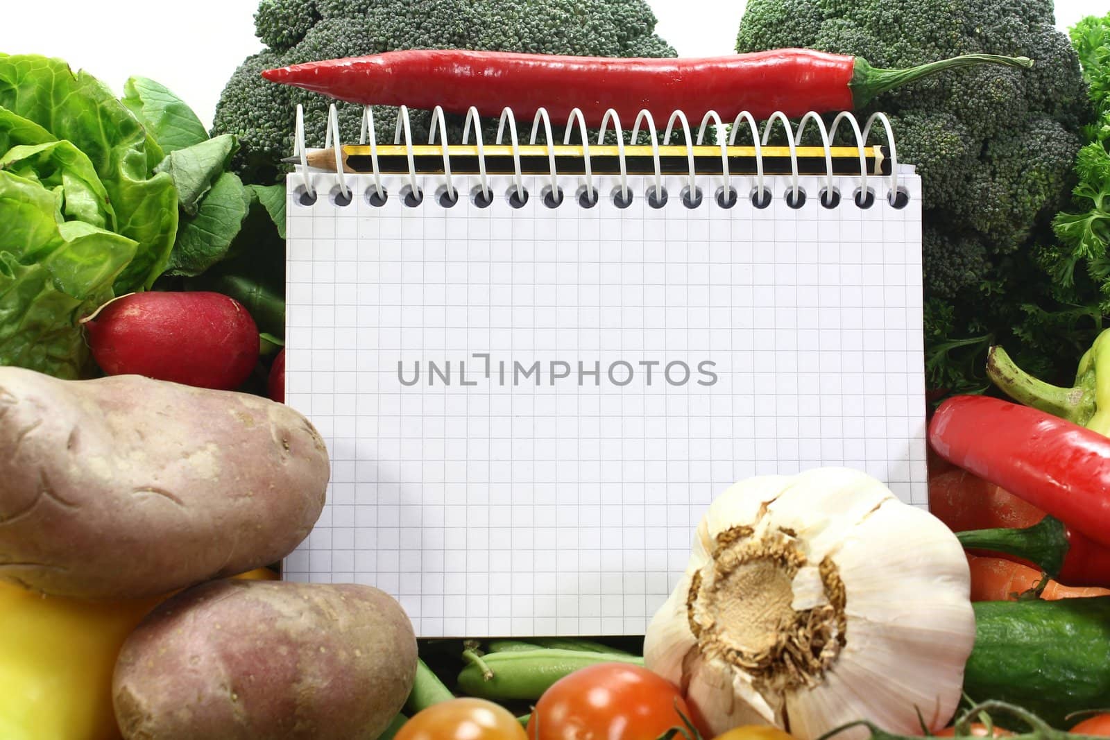 a checkered note pad and various vegetables