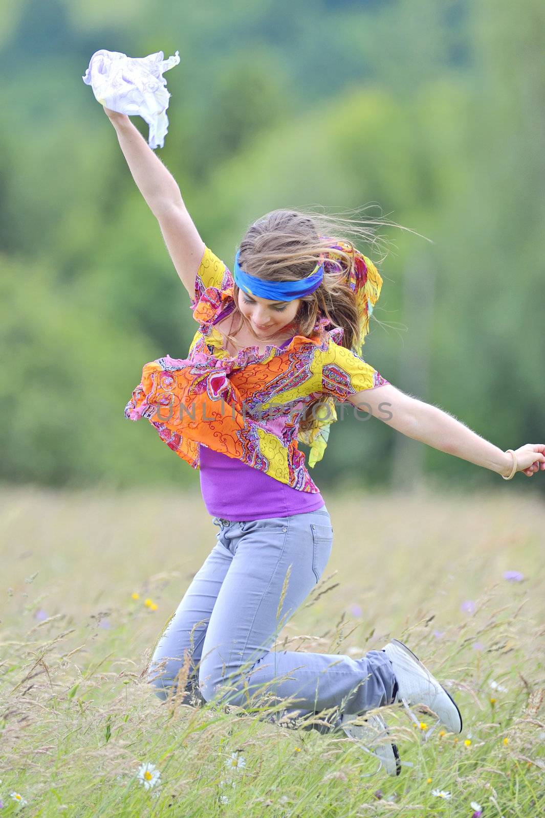 Jumping girl against summer meadow