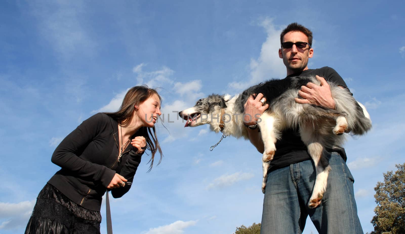 a youg couple and their dog border collie