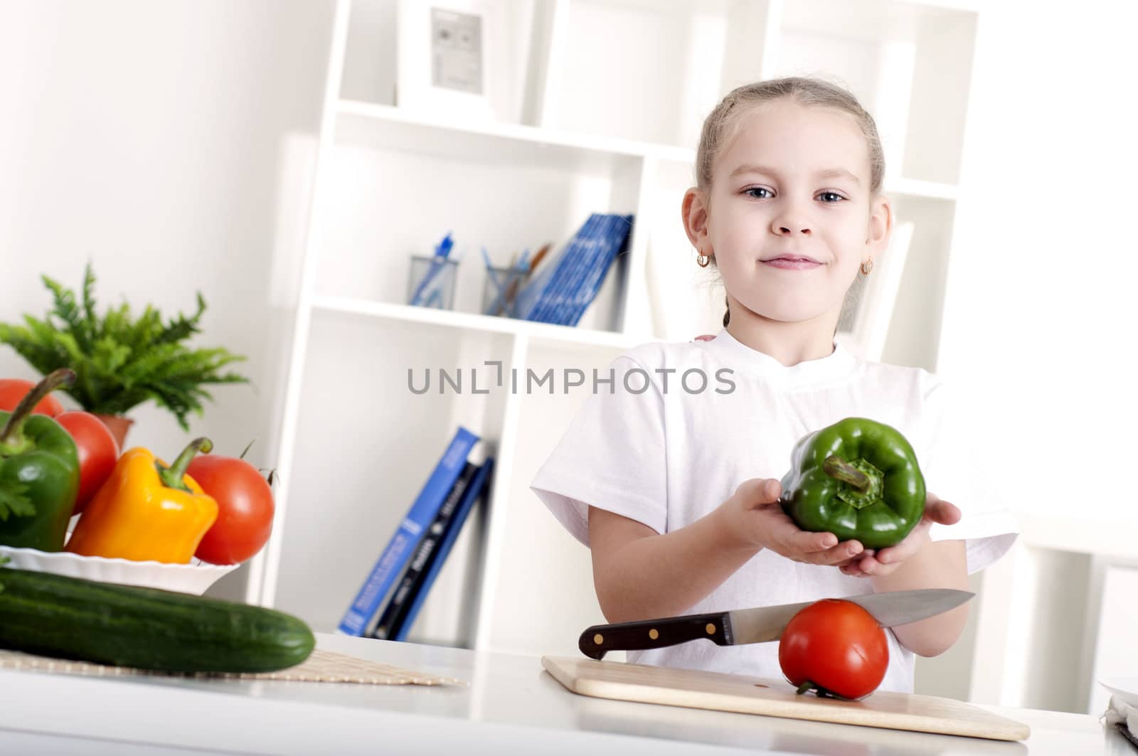 beautiful girl in the kitchen cooking vegetables