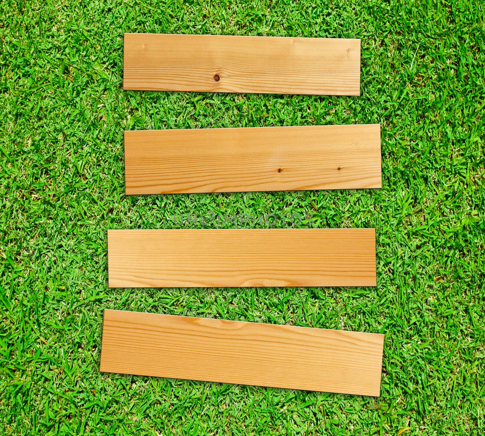 Wooden board on green grass