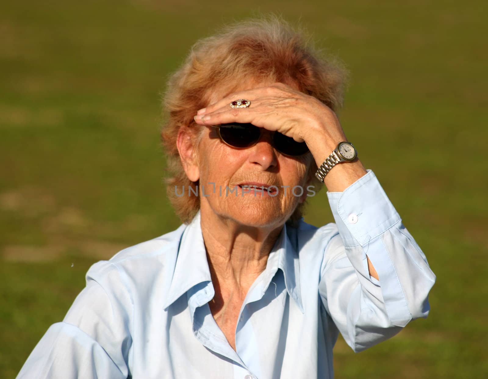 a senior woman watching the horizon with her hand on her eyes