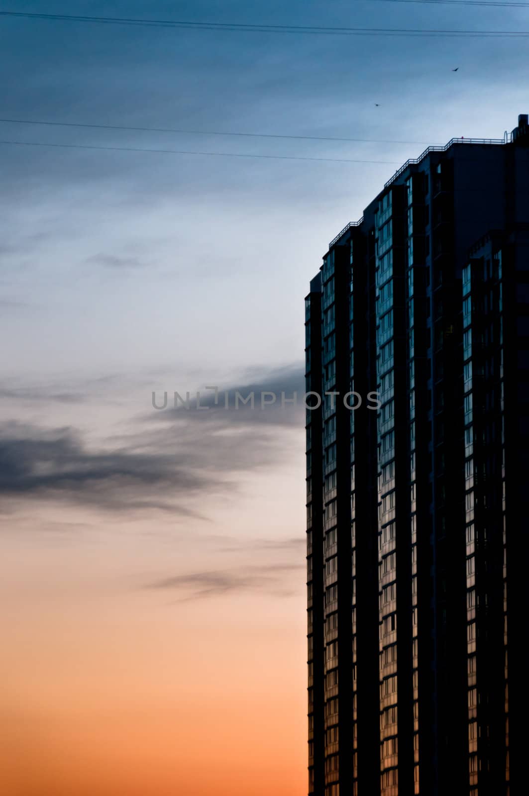 Modern skyscraper at twilight with beautiful clouds and reflections
