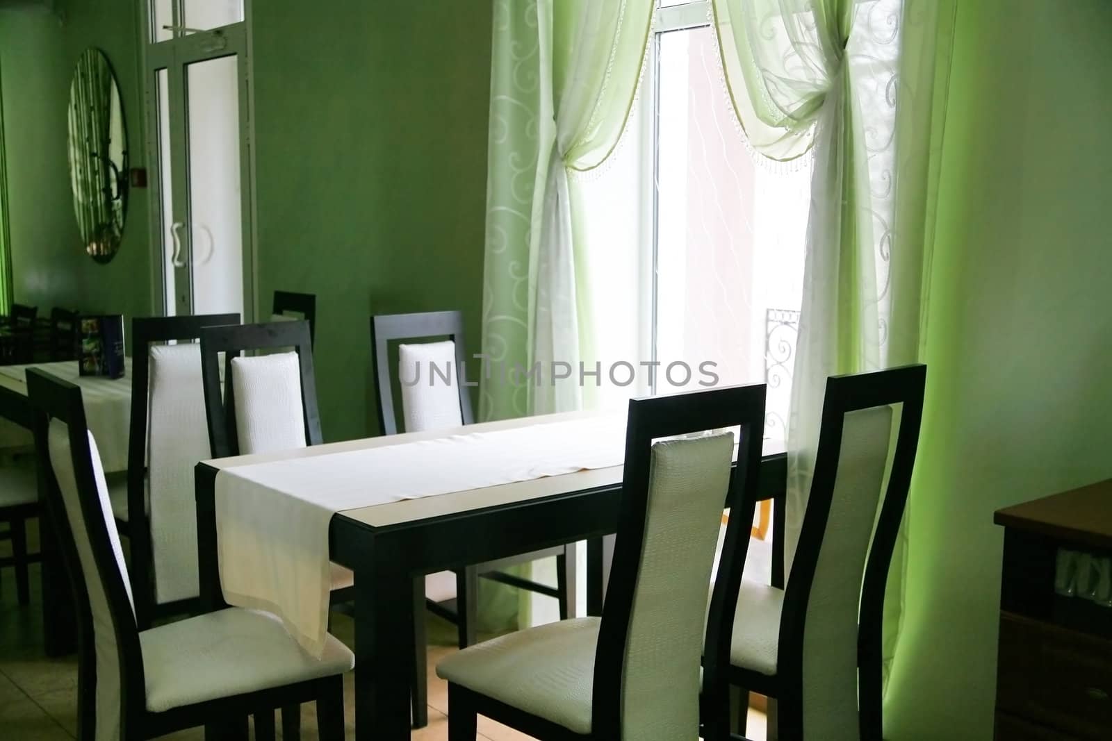 Empty cafe with a table and chairs illuminated with light from a window