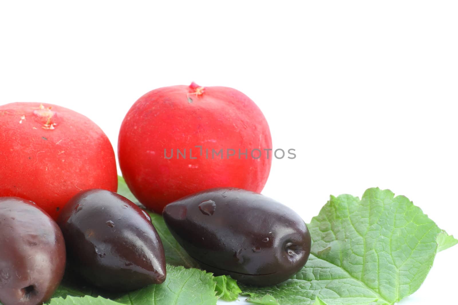 kalamata olives and red radishes on a green leaf