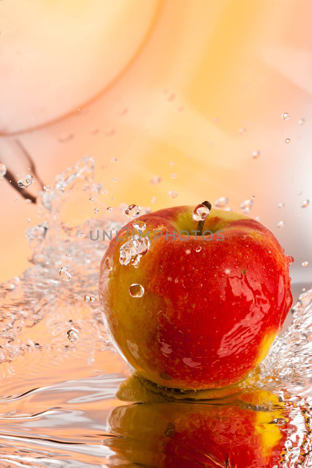 red ripe apple water splash over abstract background