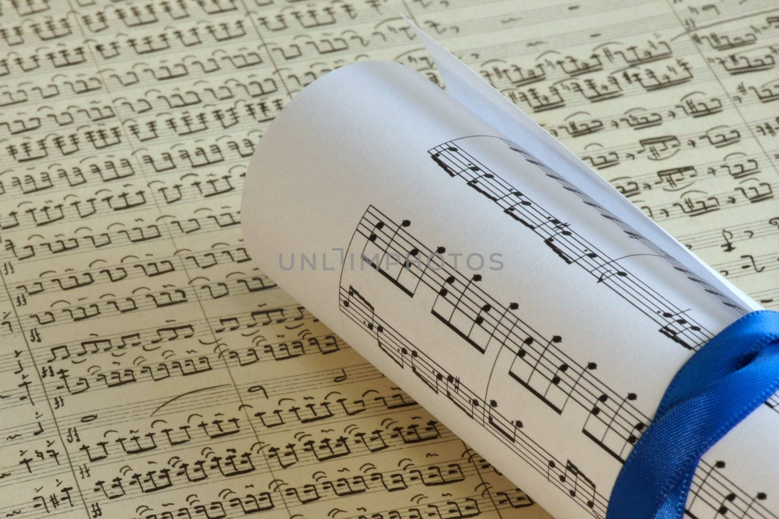 Rolled sheet music over a old sheet music