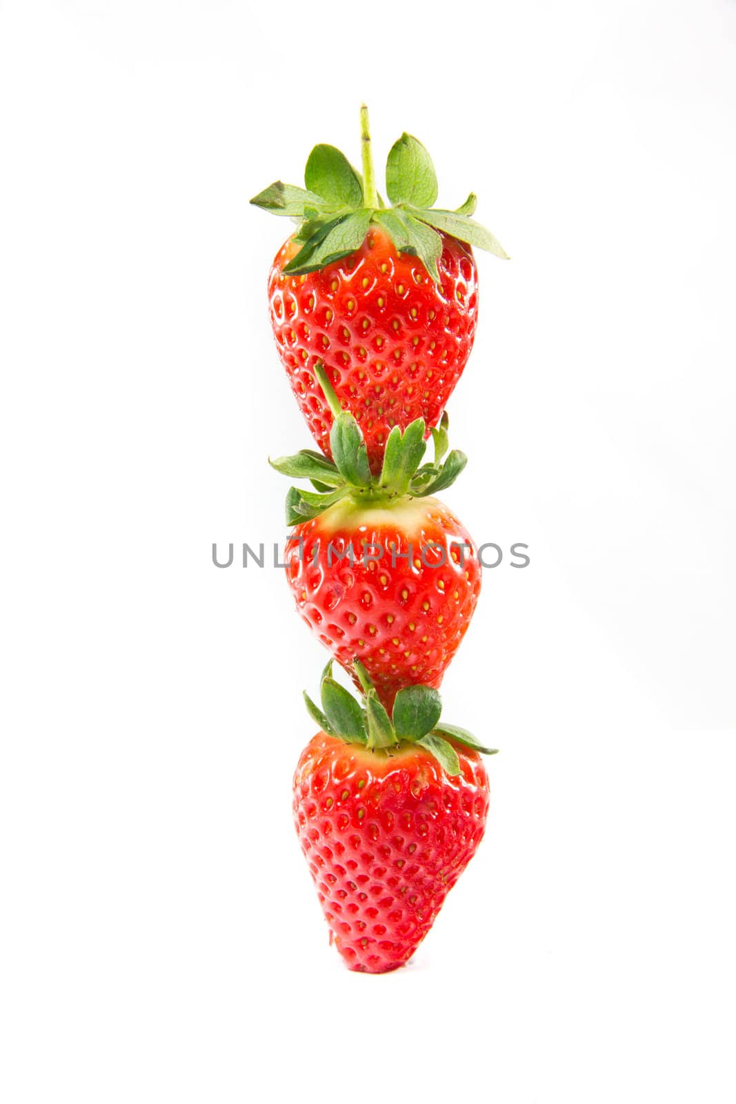 A picture of three strawberries stacked on top of eachother