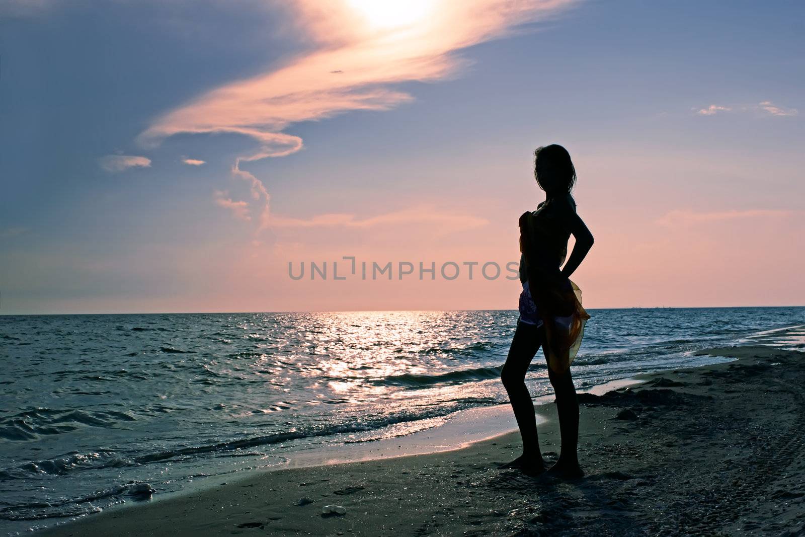 Dreamy teenage girl on the beach at sunset