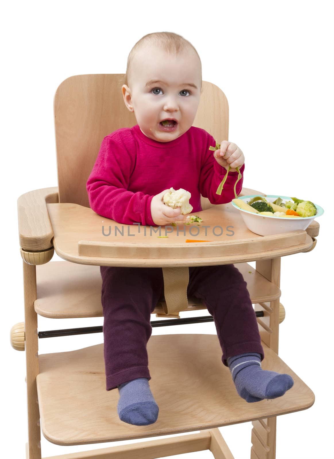 young child eating in high chair by gewoldi