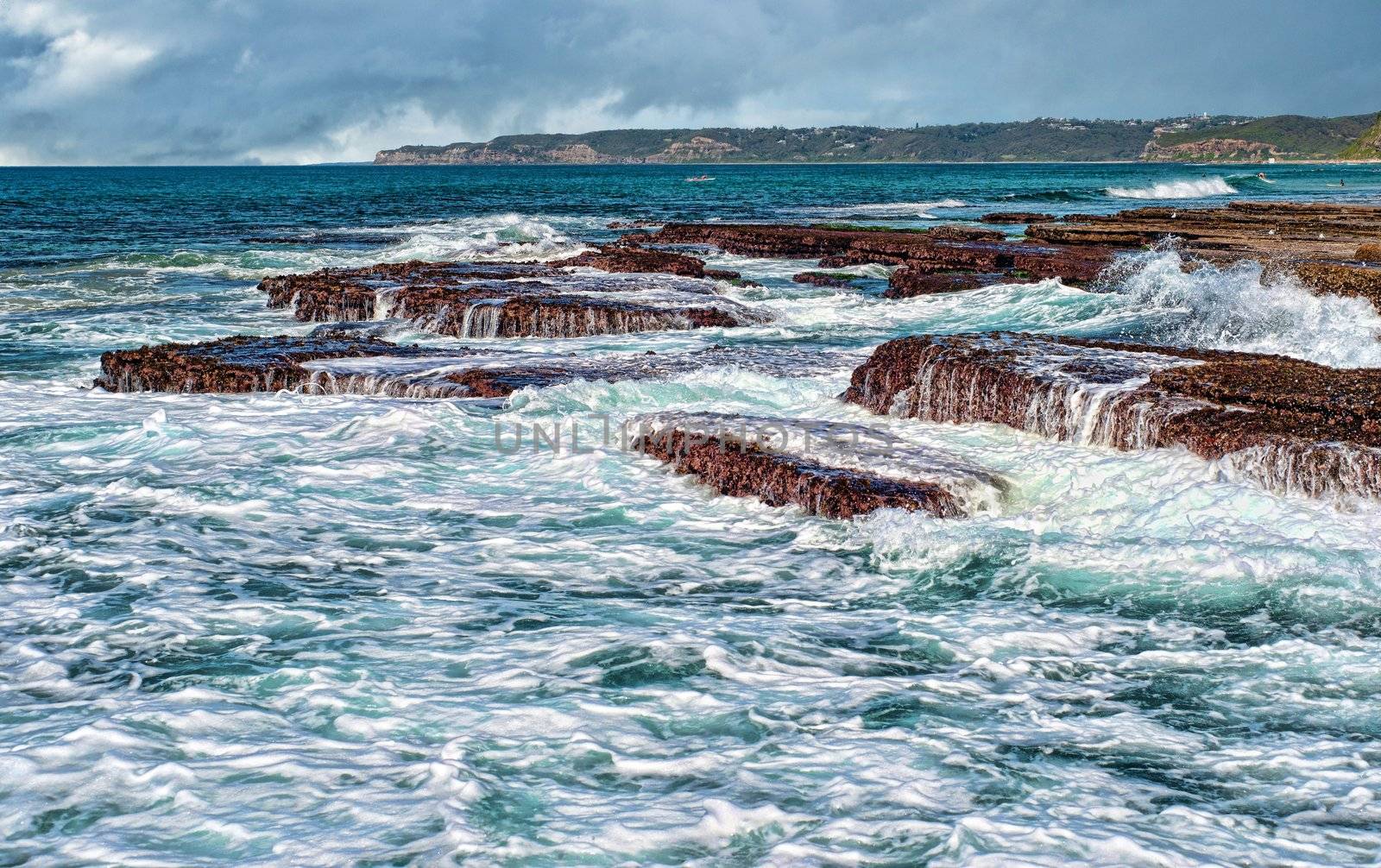 strong waves crashing onto rocks at the coast