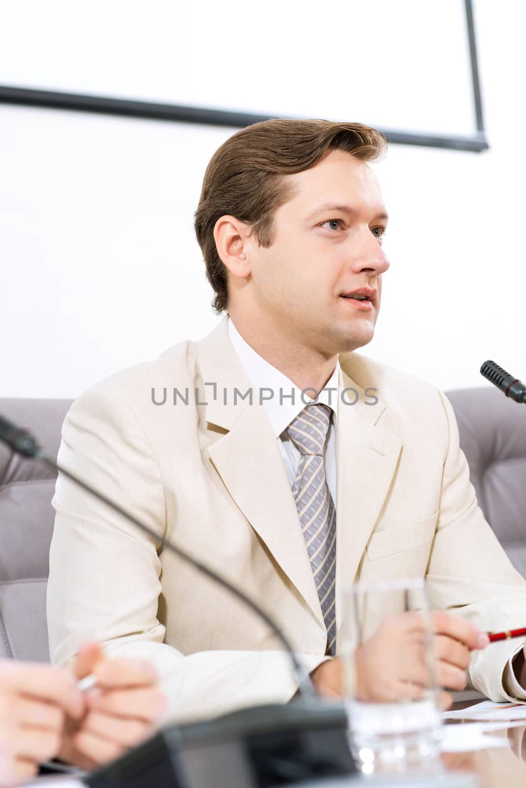 Portrait of a businessman, said into the microphone, the meeting