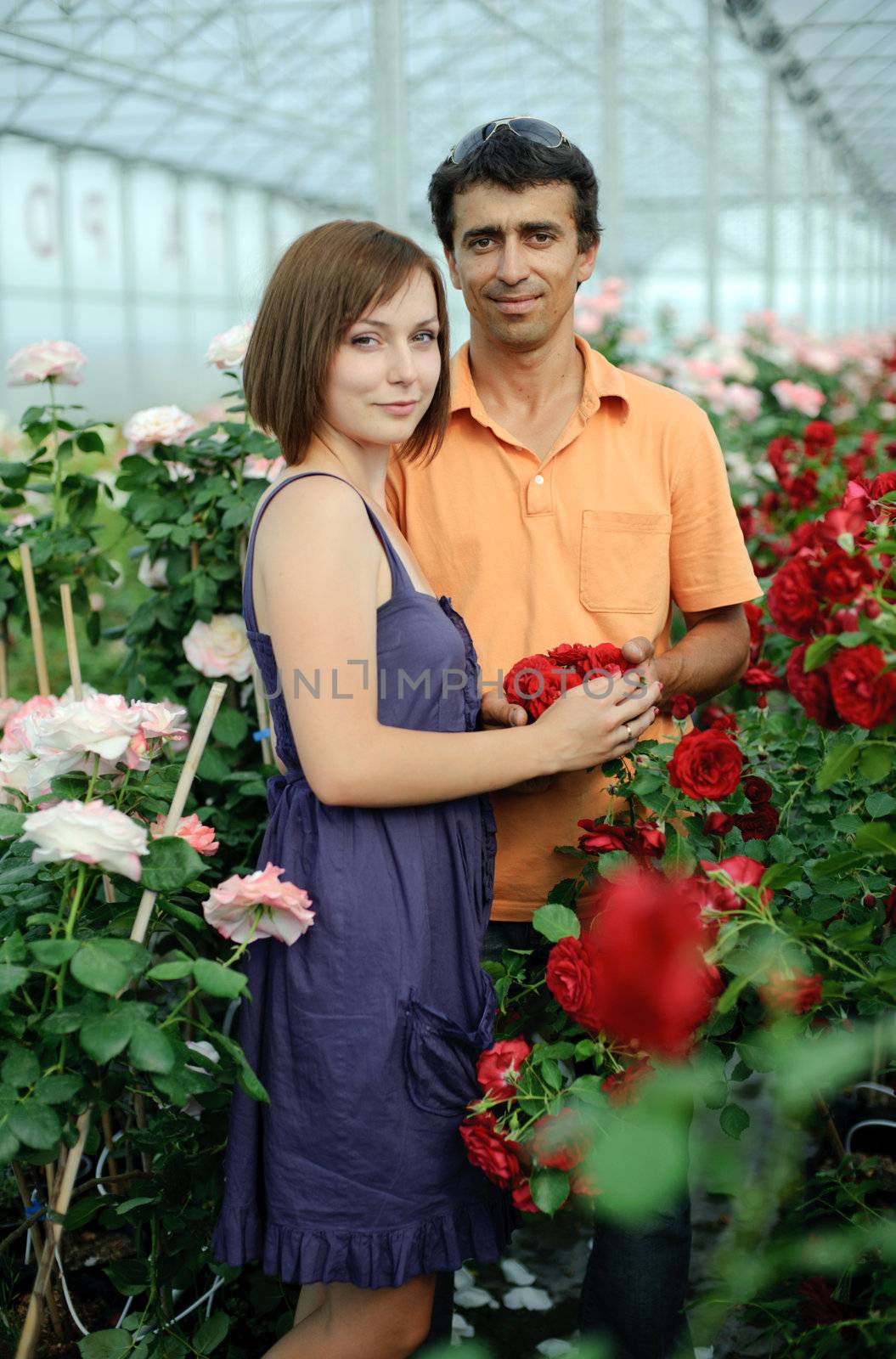 An image of a woman and a man in a greenhouse