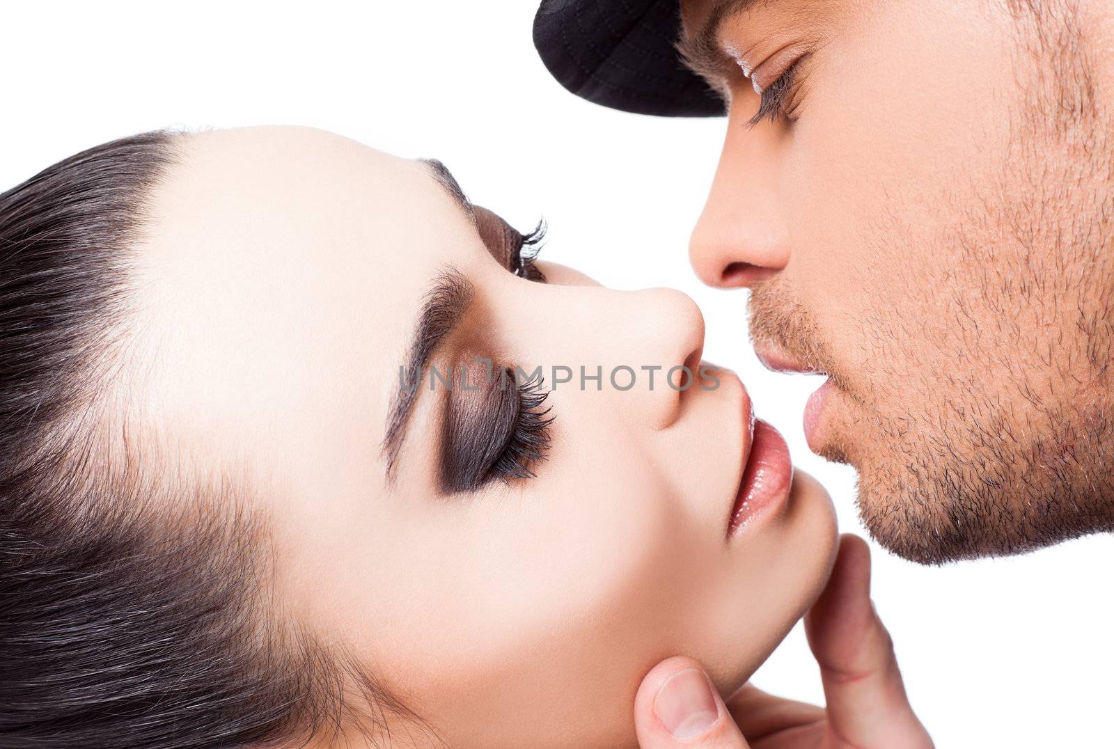 Close-up of young couple about to kiss, man holding woman's face