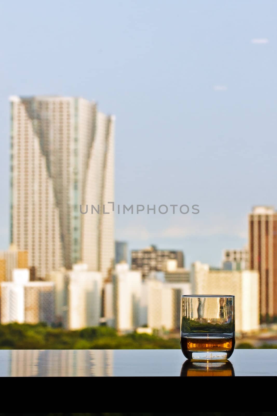 A glass of whisky with city view on background by dsmsoft