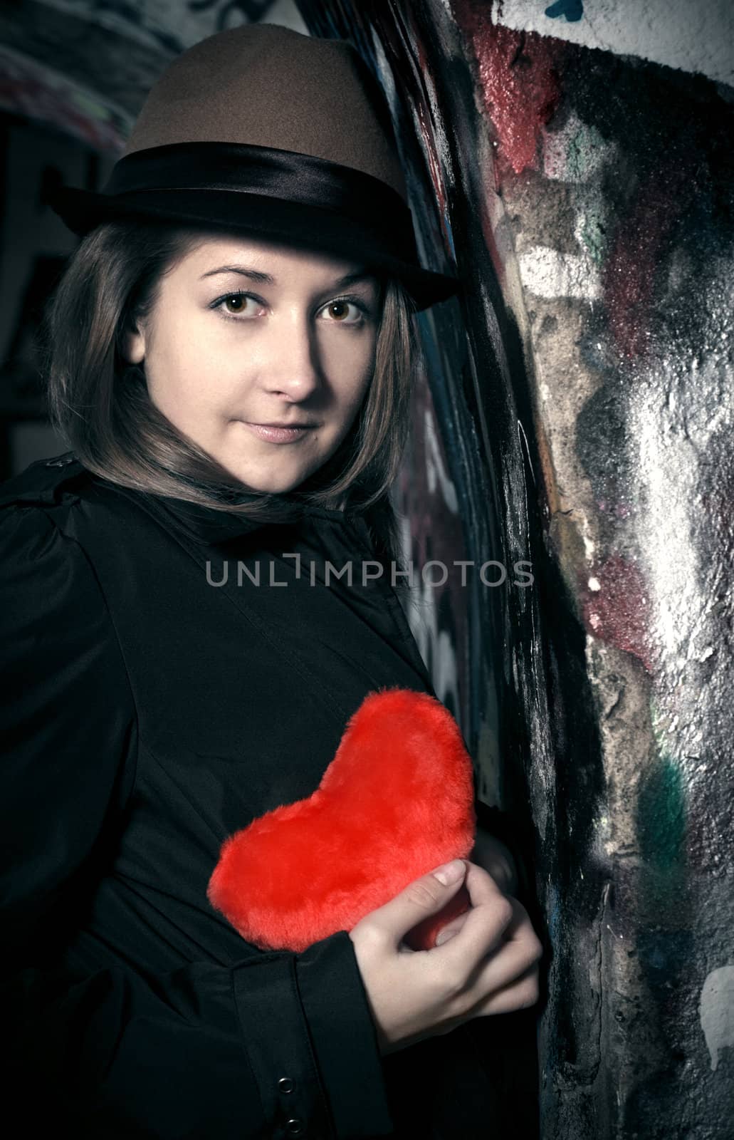 sad girl with toy heart in dark town