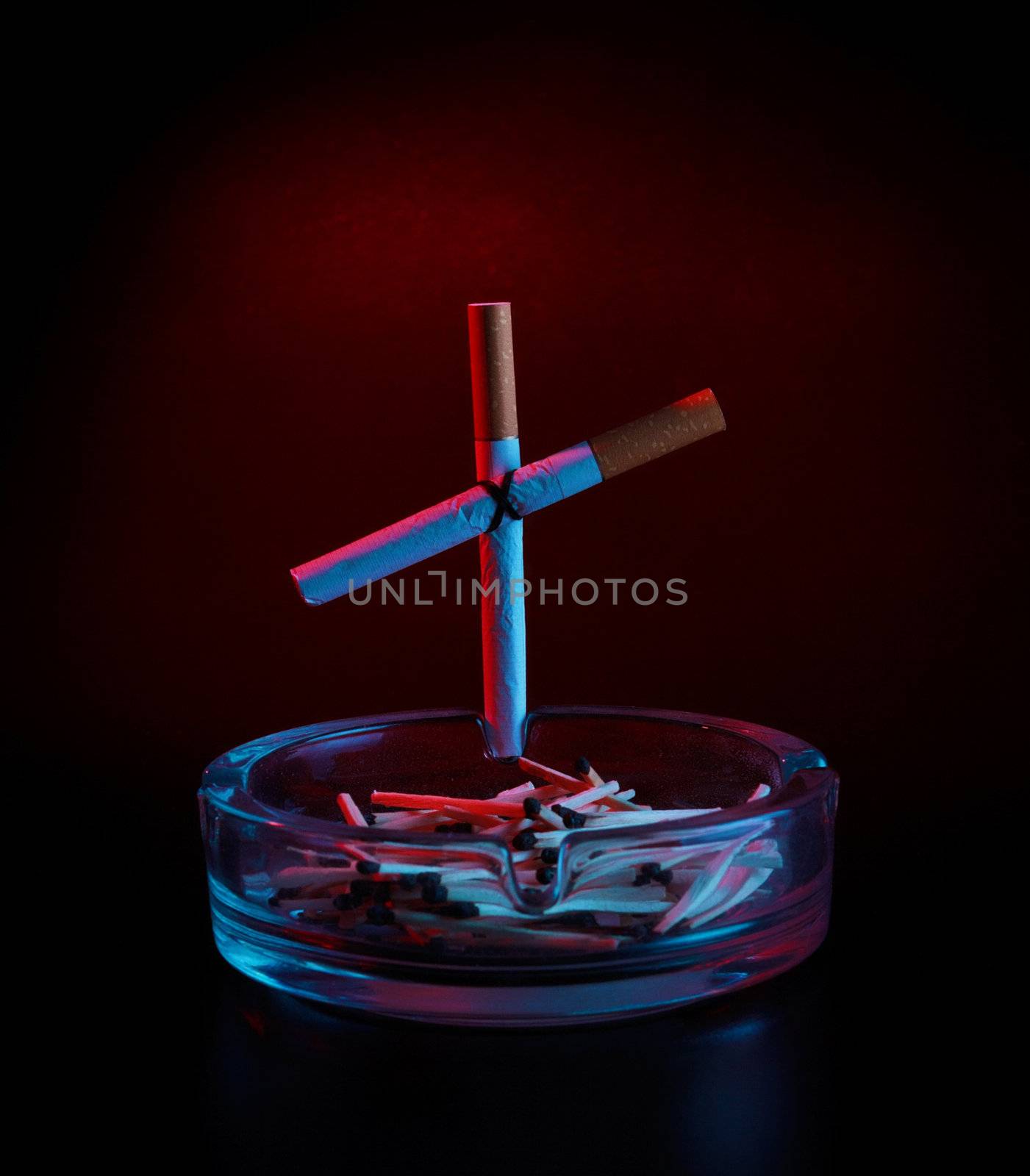 cigarette cross on ashtray, dark background