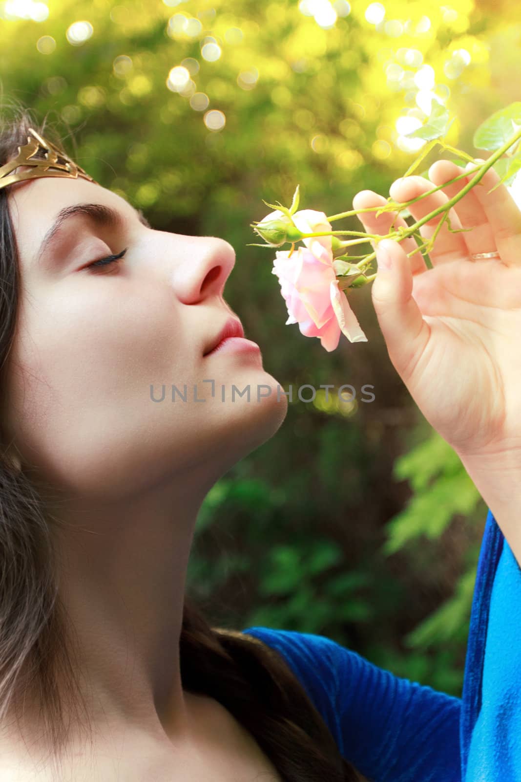 beautiful medieval princess sniffing pink wild rose