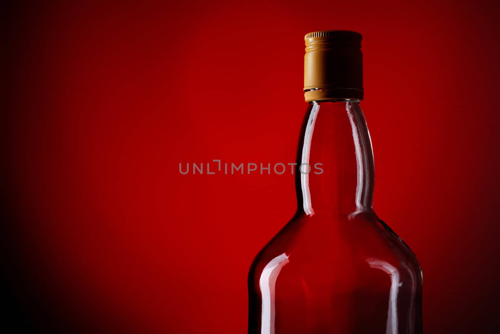 bottle of whiskey on deep red background