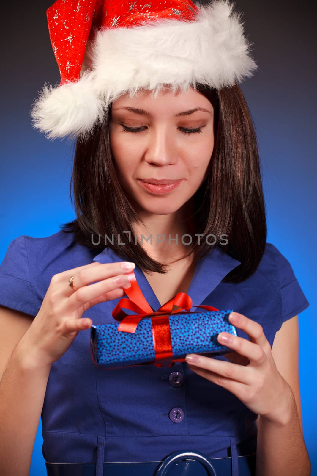 beautiful christmas girl opening gift, blue background