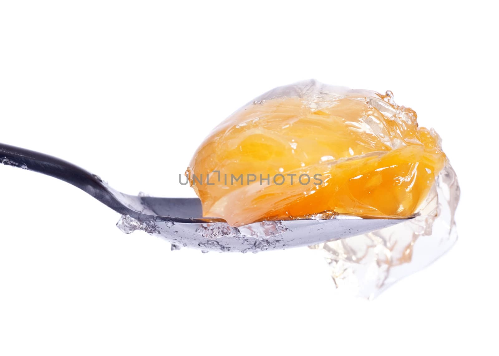 mandarin in jelly on spoon, white background