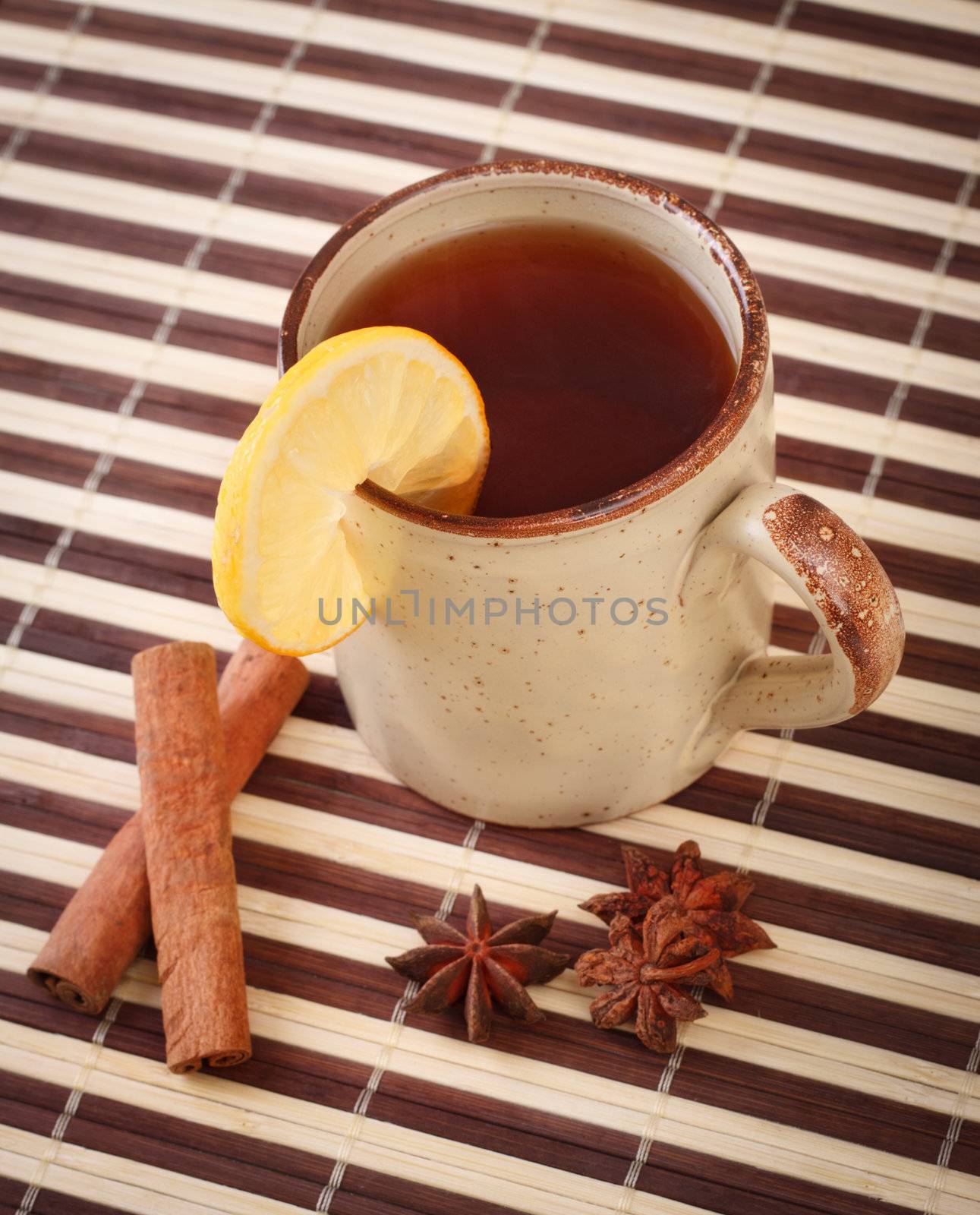 mug of winter tea with cinnamon and star anise on bamboo napkin