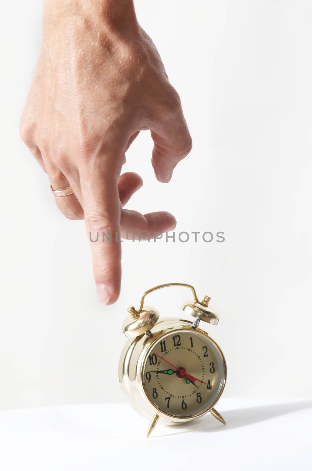 A forefinger pointing at on alarm clock