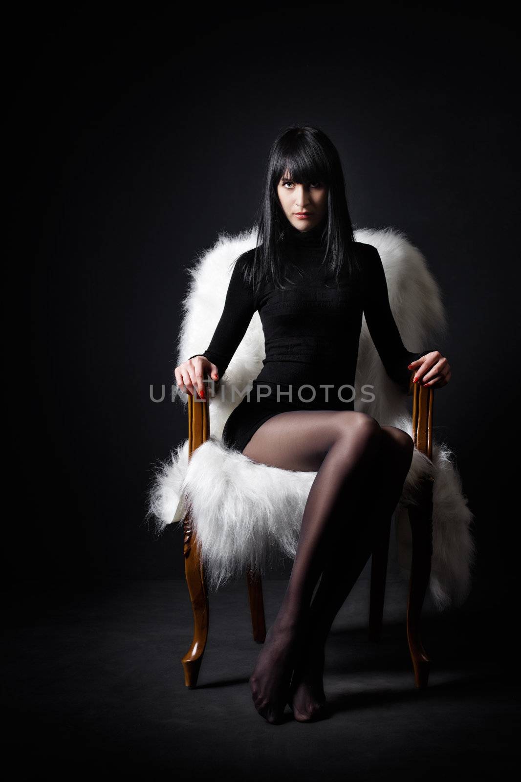 Sexy girl in a chair, black background