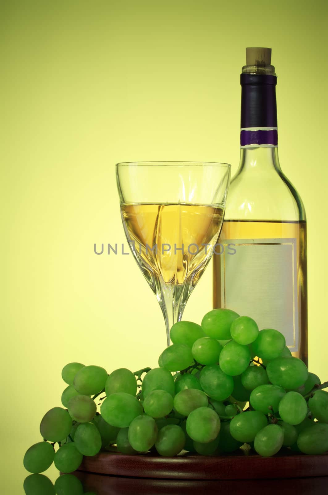 bottle and glass of wine, grape bunch, green background