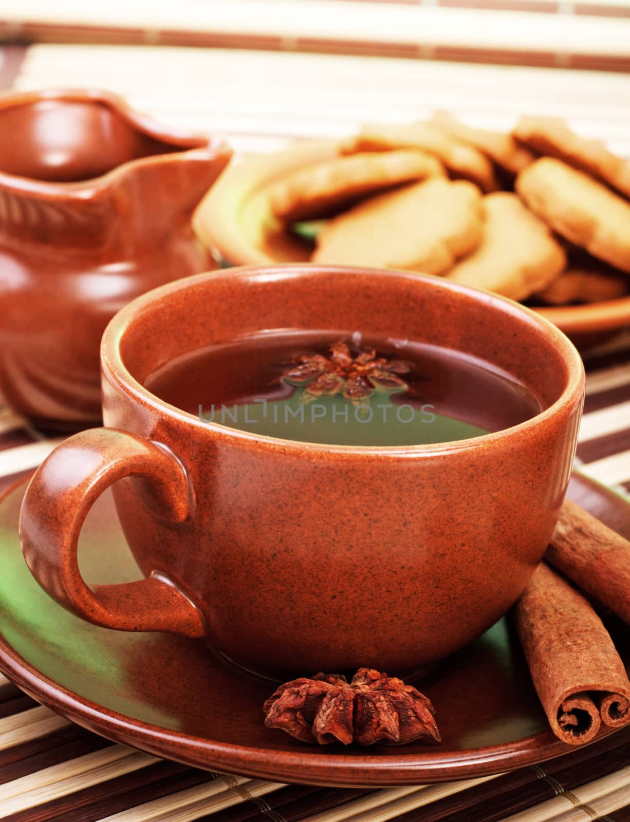 cup of winter tea with cinnamon and star anise on bamboo napkin