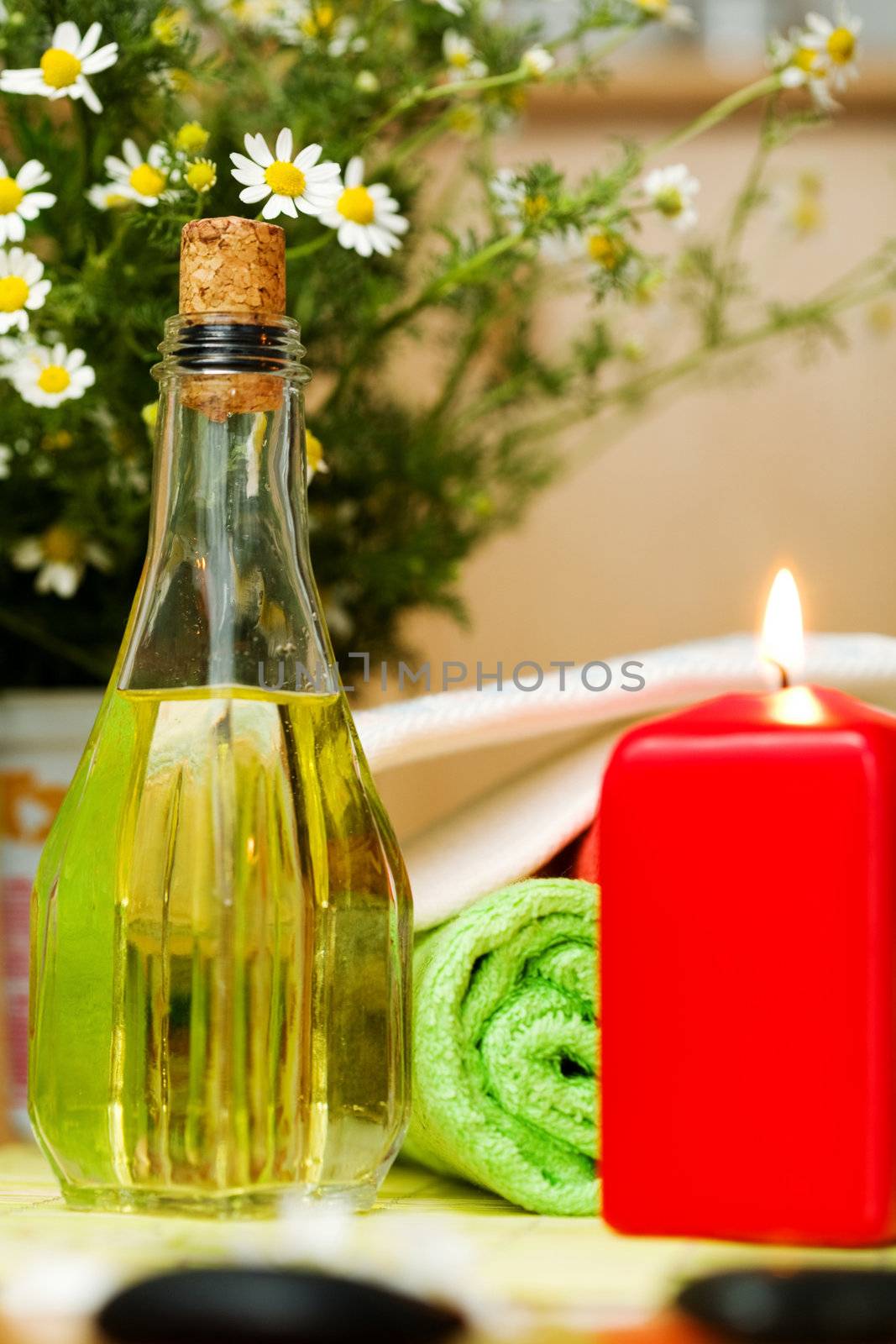 An image of a bottle of oil and a candle