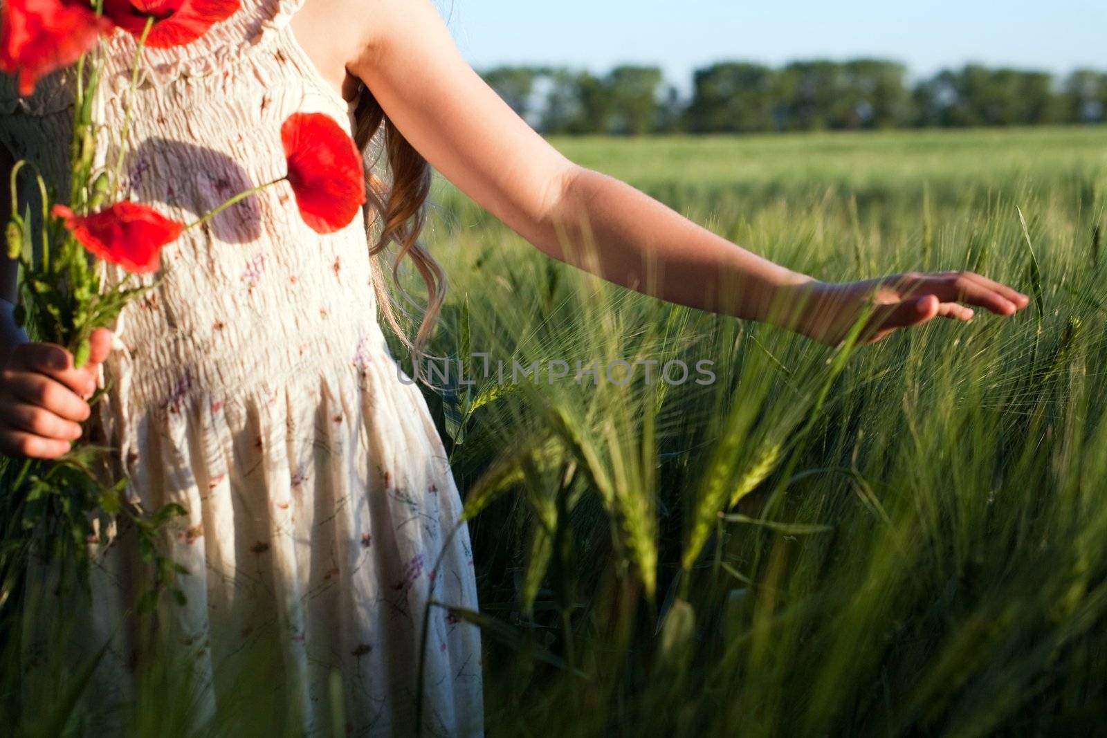 An image of a beautiful girl in the field with poppies
