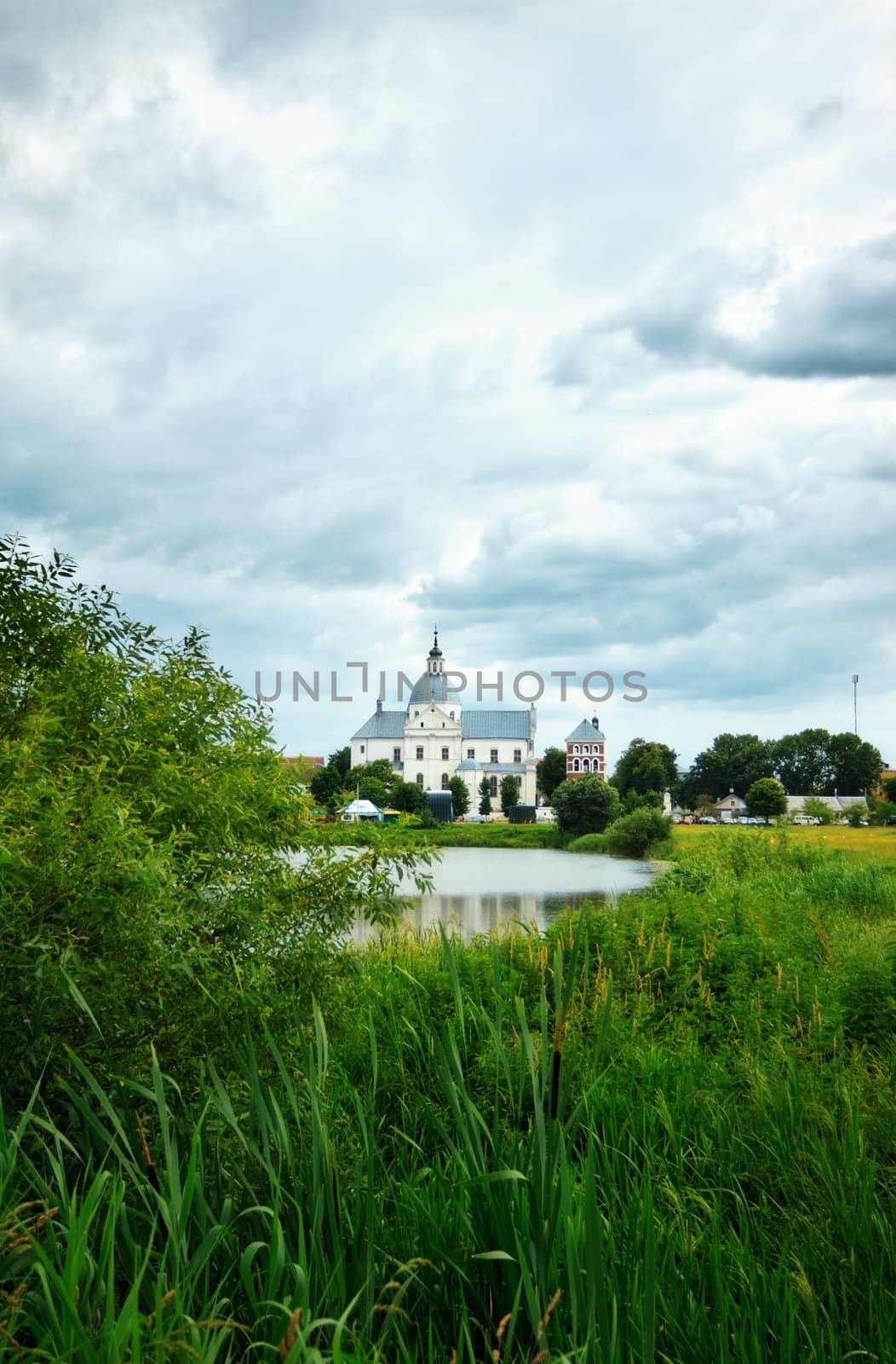 monastery on calm lake at cloudy day