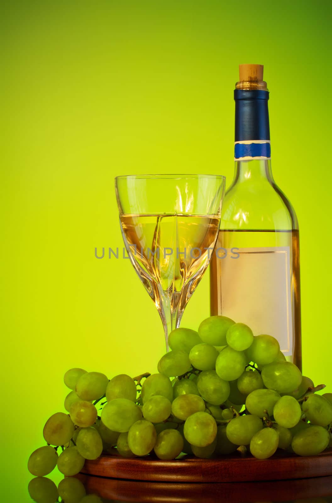 bottle and glass of wine, grape bunch, green background